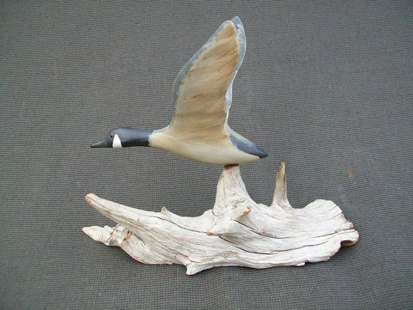 Miniature flying Canada Goose on driftwood stand