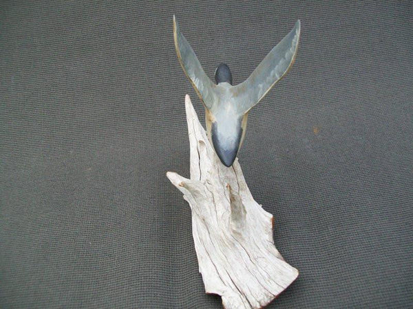 Miniature flying Canada Goose on driftwood stand